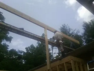 Carpenter setting a ridge beam over a new addition frame — Ice Dam Removal by Roofing Brothers in Ronks