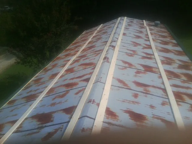 Rusted metal roof panels with new wood purlins before replacement — Storm Damage Roof Repair in Ronks by Roofing Brothers