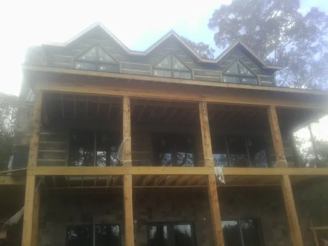 Dormers and porch framing on a large log home under construction — Roof Coating work by our crew in Ronks