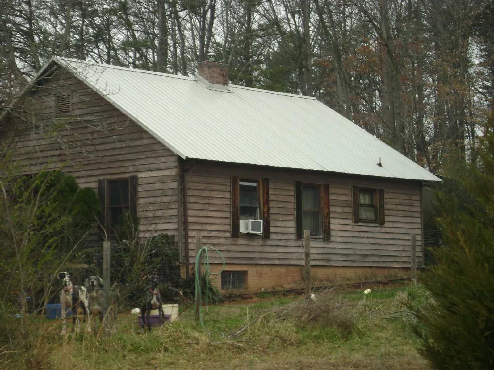 White metal roof on an old wood sided farmhouse, from a Metal Roof Installation job in Ronks